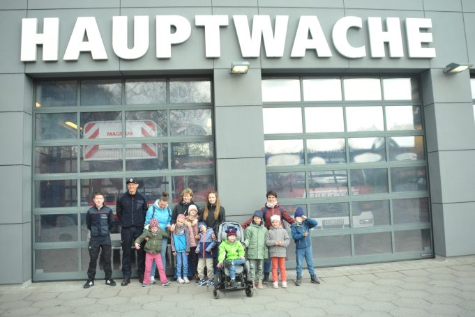 Gruppe von Kindern und Erwachsenen vor dem Gebäude der Hauptwache.